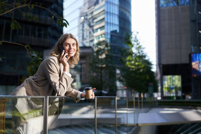 Portrait of young woman looking away in city