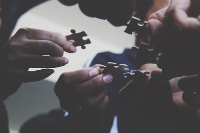 Close-up of hands holding jigsaw pieces