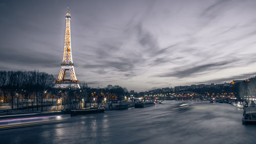 Illuminated tower against cloudy sky