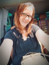 Portrait of smiling young woman sitting in car