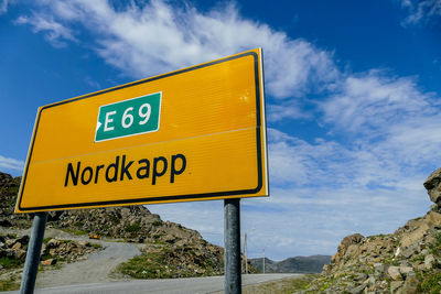 Low angle view of information sign against sky