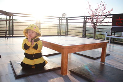 Boy looking away while sitting on table