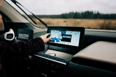 Midsection of man using mobile phone in car