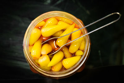 High angle view of yellow eggs in glass container on table