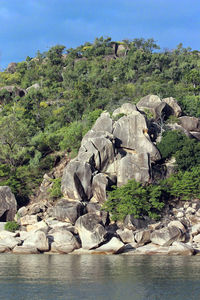 Rocks by sea against sky