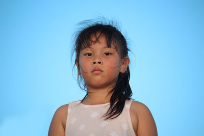 Portrait of cute girl against clear blue sky