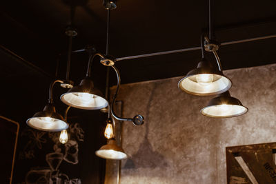 Illuminated electric lamp on table against wall