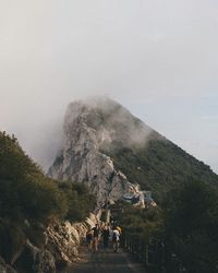 People on mountain against sky