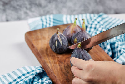 Close-up of hand holding banana on cutting board