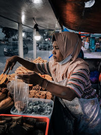 Midsection of woman preparing food in restaurant