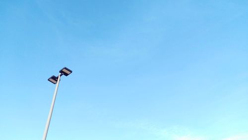 Low angle view of street light against blue sky