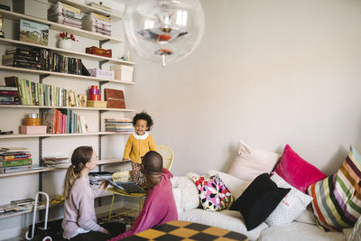 Parents reading book to daughter in living room