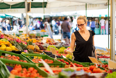 Mid adult woman standing at market stall