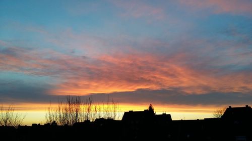 Silhouette buildings against sky during sunset