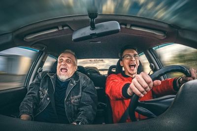 Men screaming while riding car