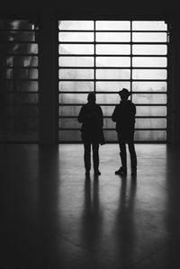 Full length of friends standing on floor in building
