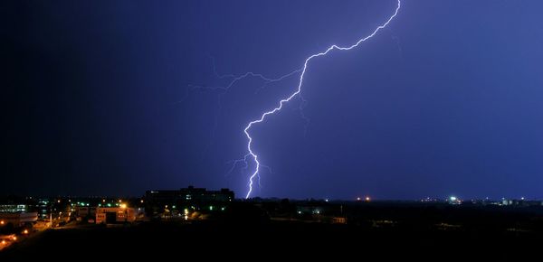 Lightning strike above illuminated townscape