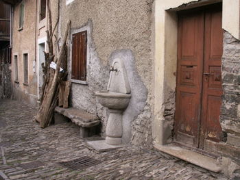 Stone sink mounted on wall of old house in town
