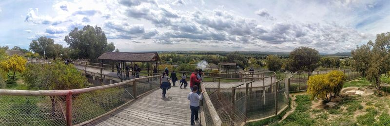 Rear view of people walking on footbridge