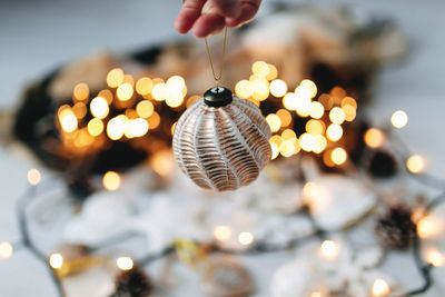 Hand is holding white christmas tree toy