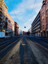 Surface level of railroad tracks by buildings against sky