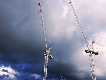 Low angle view of cranes against sky