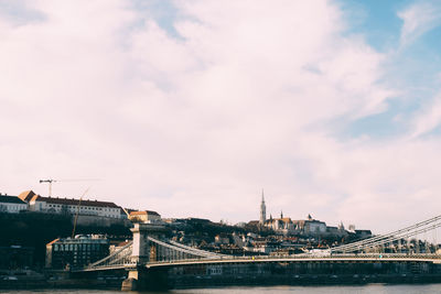 Bridge over river with city in background