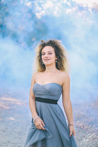 Portrait of young woman standing on field