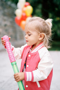 Portrait of cute girl with arms crossed standing outdoors