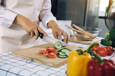 Midsection of man cutting vegetables on cutting board