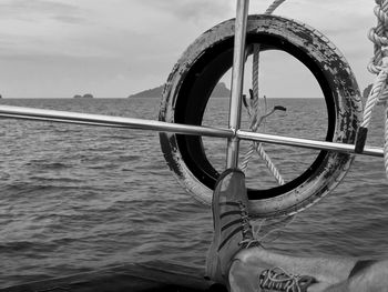 Close-up of boat sailing on sea against sky
