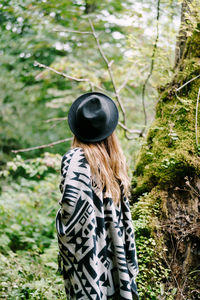 Rear view of woman wearing hat in forest