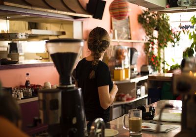 Rear view of woman standing in cafe