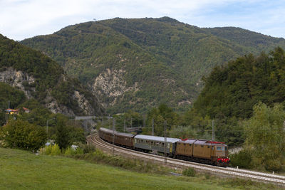 Train on railroad track by mountains