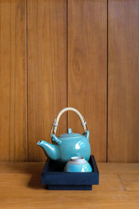 Close-up of blue wooden table against wall at home