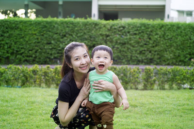 Portrait of mother and son on grass