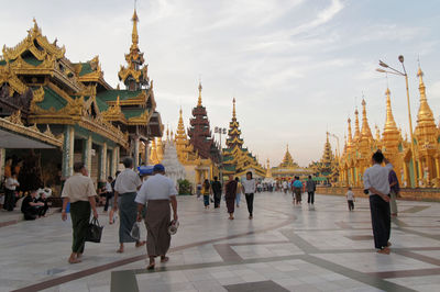 People walking in temple against sky