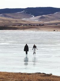 Couple walking on frozen lake baikal in russia