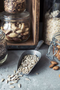 Close-up of seeds in serving scoop against jars on kitchen counter