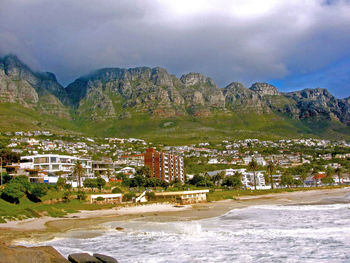 Camps bay by sea shore against mountains