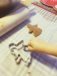 Close-up of hand holding cookies on table