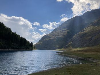 Scenic view of lake by mountains against sky