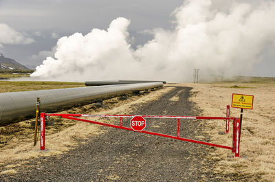 Fence, road, pipeline, hot steam and danger sign at the hellisheiði geothermal power plant