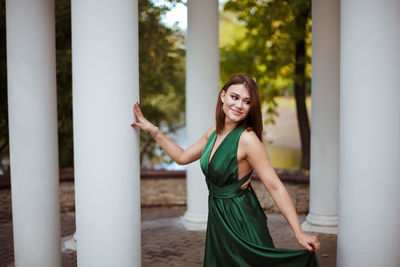 Smiling young woman looking away while standing outdoors