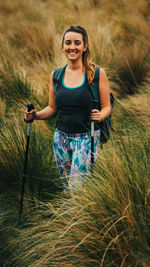 Portrait of smiling young woman standing on field