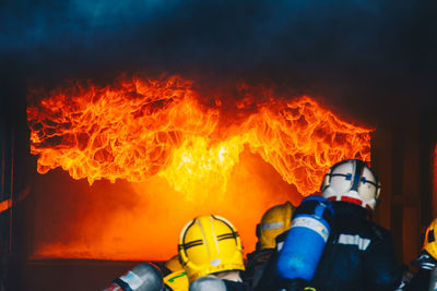 Rear view of firefighters extinguishing fire