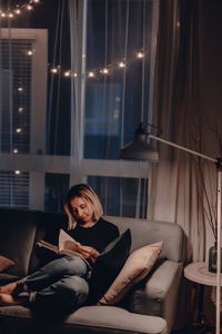 Woman sitting on sofa at home