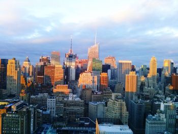 Buildings in city against cloudy sky