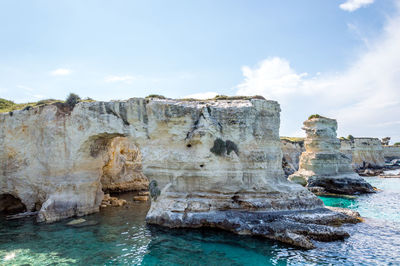 Rock formation in sea against sky