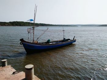 Boat sailing in sea against clear sky